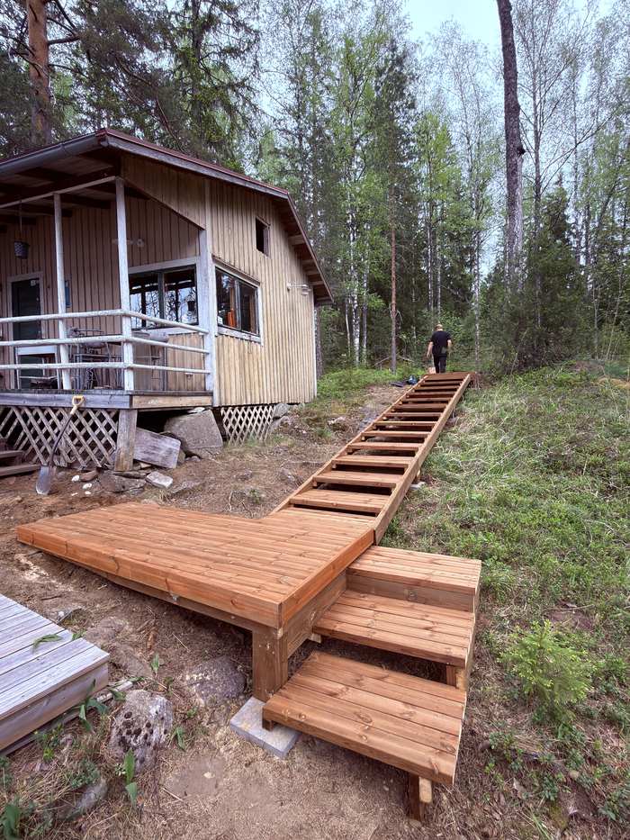 Portaat ja terassi rinteessä mökin vierellä